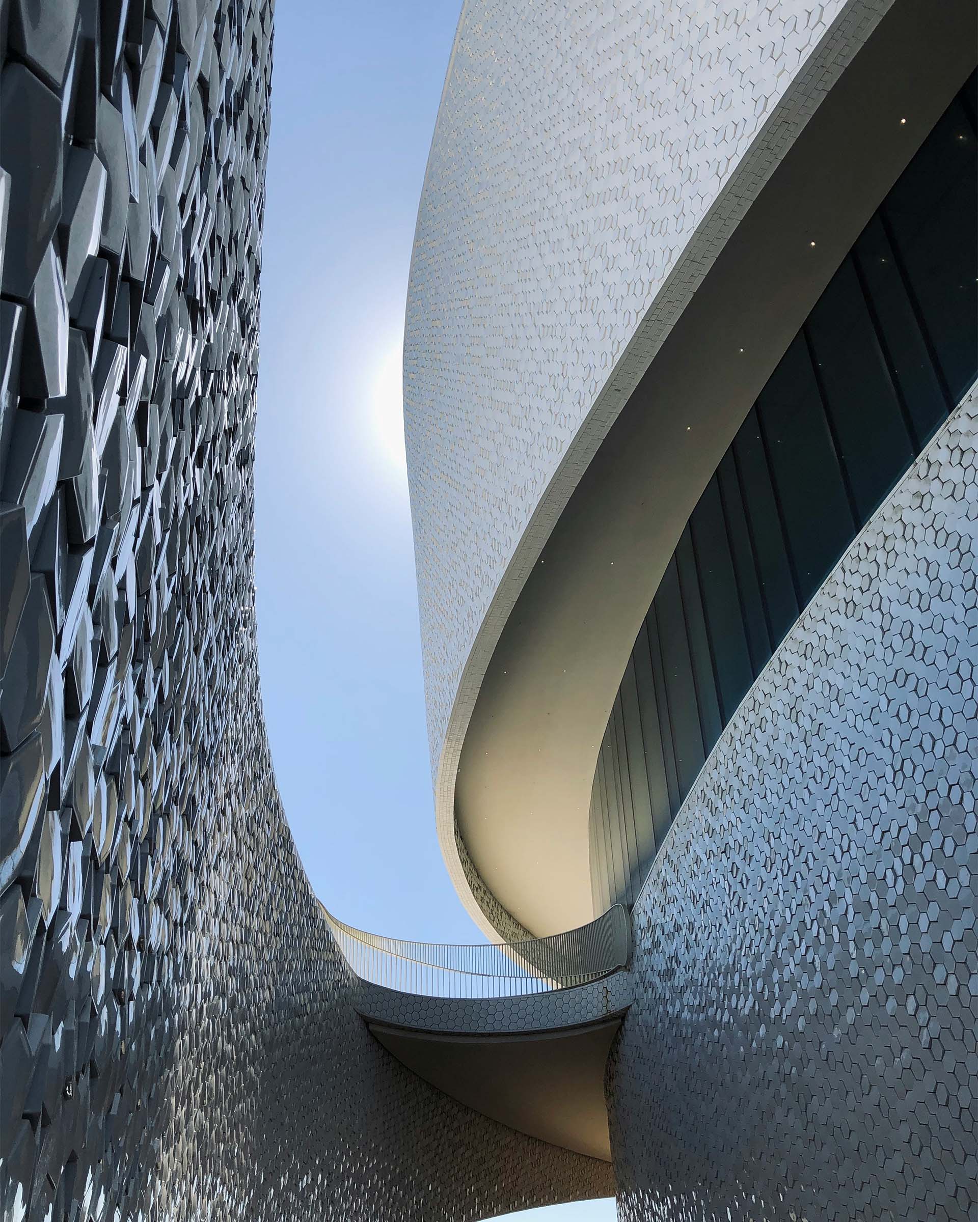 A close up of a modular hexagonal building with a sky background