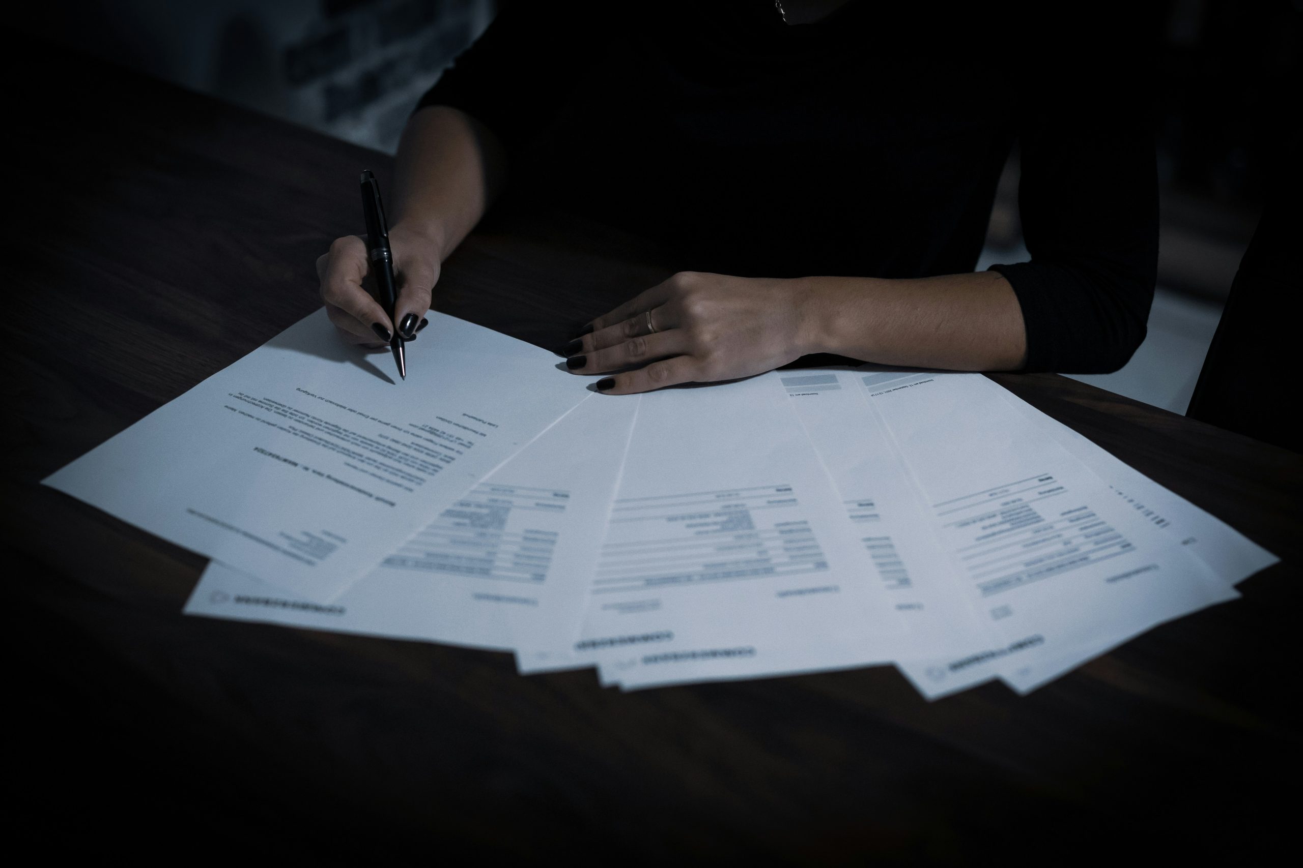A group of people sitting around a table working on laptops